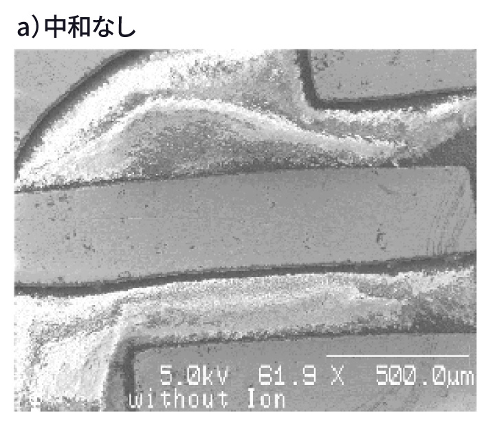 a) 帯電中和なしで取得したSEM像（帯電により像が乱れている、5.0kV 61.9倍 500µm）